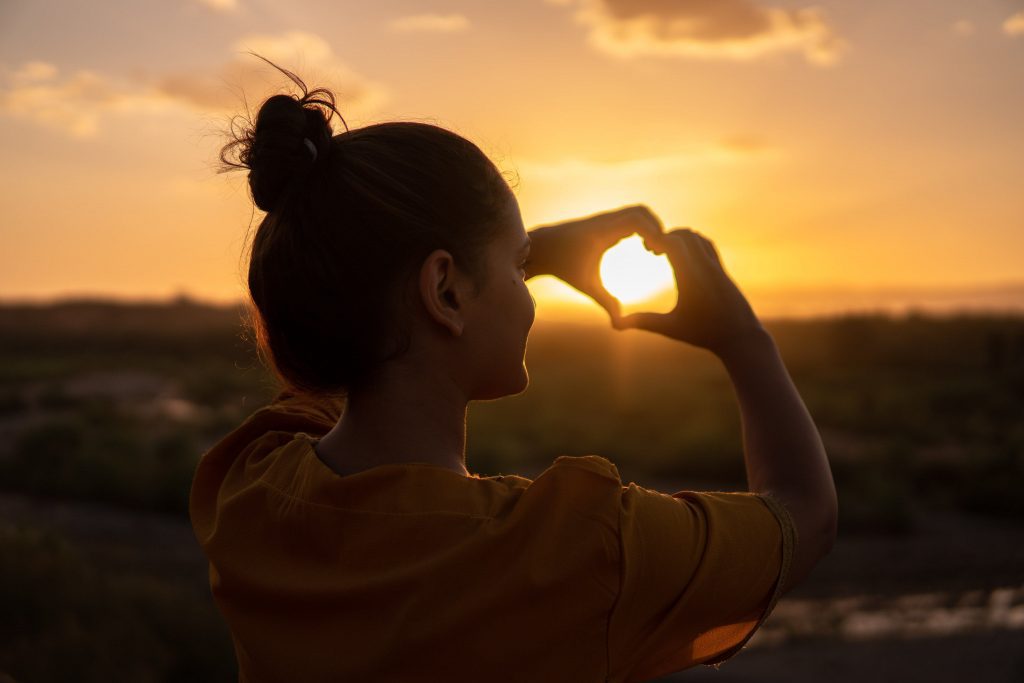 mujer creando un corazón con sus manos - tendencias de viaje